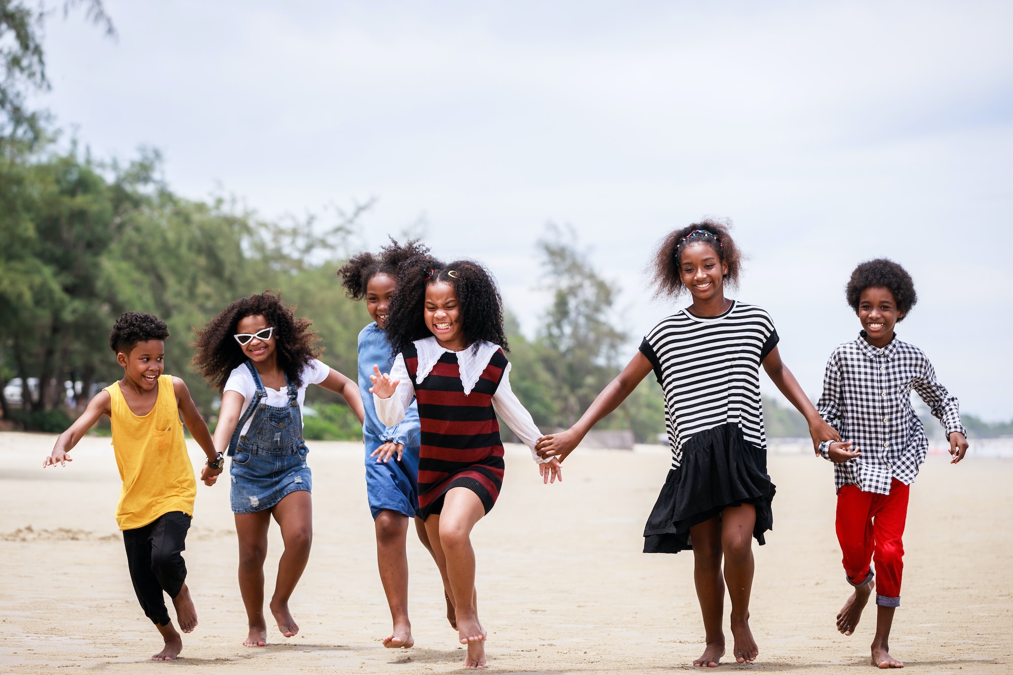 Funny vacation. Children or kids playing and romping together at the beach on holiday.